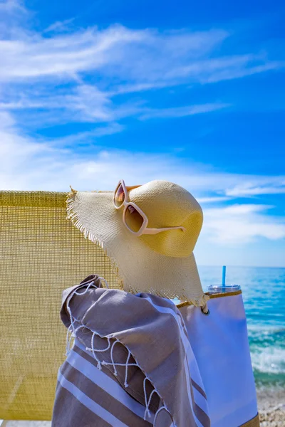 Playa con tumbona, toalla, bolso, sombrero — Foto de Stock