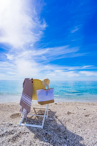 Beach with deck chair, towel, bag, hat — Stock Photo, Image