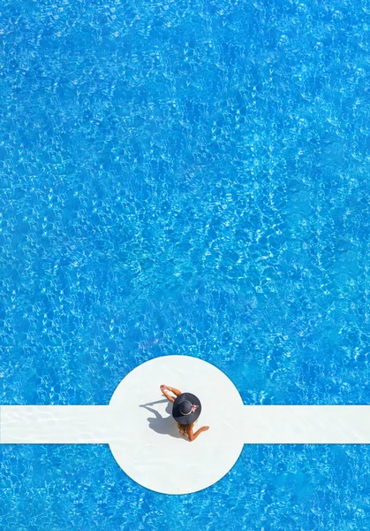 모자는 수영장의 가장자리에 앉아 여자 — 스톡 사진