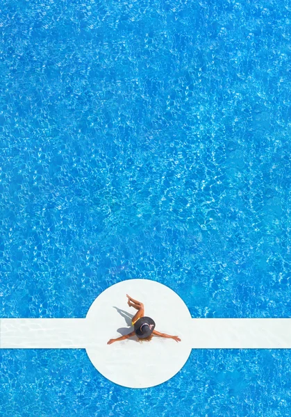 一顶帽子，坐在游泳池边上的女人 — 图库照片