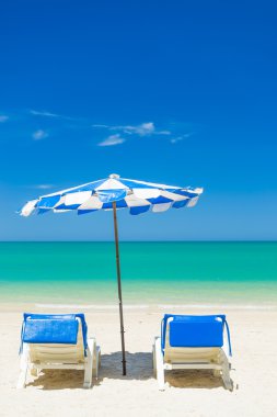 Plaj sandalyeleri bulutlu mavi gökyüzü ile kum plaj 