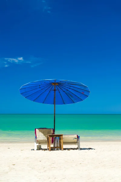 Plážová lehátka na písčité pláži s modrou oblohou — Stock fotografie