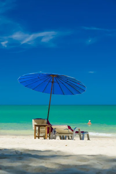 Plážová lehátka na písčité pláži s modrou oblohou — Stock fotografie