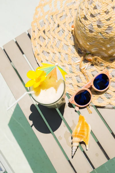 Mesa de piscina com óculos de sol, chapéu e coquetel fresco — Fotografia de Stock