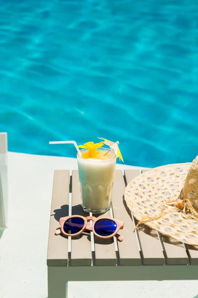 Swimming pool asztal napszemüveg, kalap és friss koktél — Stock Fotó