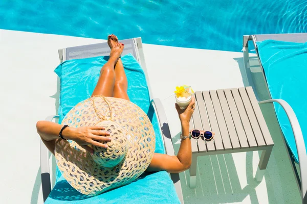 Mulher à beira da piscina com coquetel pina colada — Fotografia de Stock