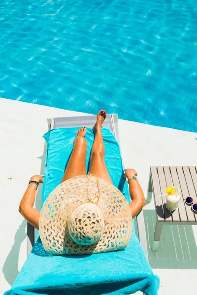 Vrouw bij het zwembad met pina colada cocktail — Stockfoto