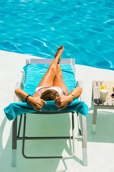 Жінка танцює, насолоджуючись сонячним ліжком у басейні — стокове фото