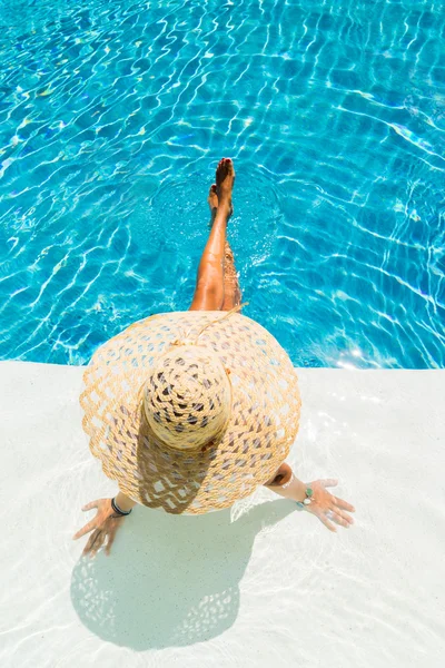 Vrouw met hoed bij het zwembad — Stockfoto