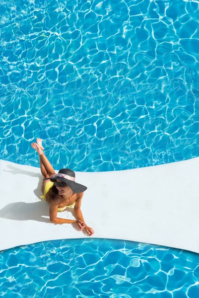 Όμορφη μαυρισμένο σπορ λεπτή γυναίκα χαλαρώνοντας στην πισίνα — Φωτογραφία Αρχείου