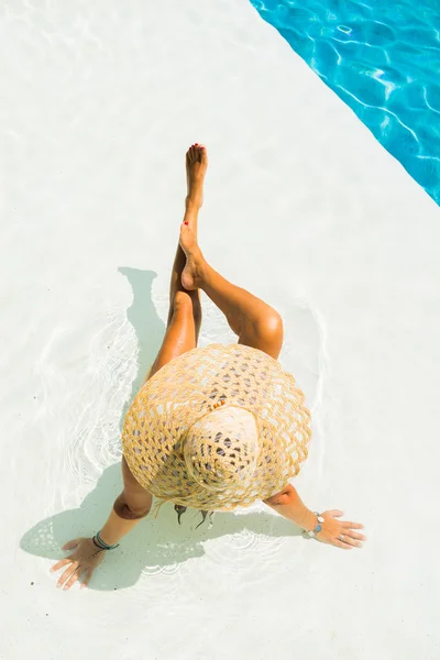 Vrouw met hoed bij het zwembad — Stockfoto