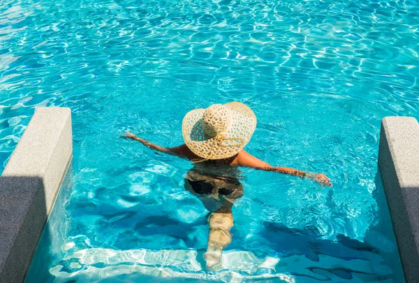 Frau mit Hut am Pool — Stockfoto