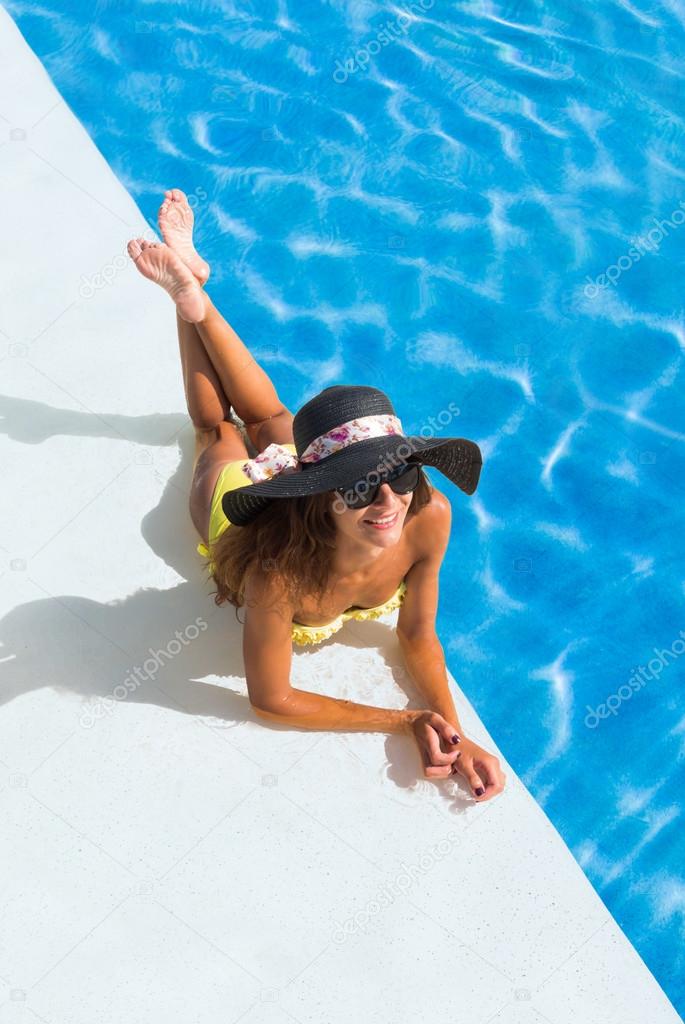 beautiful tanned sporty slim woman relaxing in swimming pool 