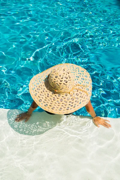 Женщина в шляпе у бассейна — стоковое фото