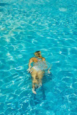 Yüzme havuzunda bikinili bir kadın suyun altında 