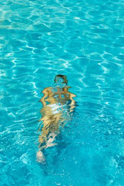 Yüzme havuzunda bikinili bir kadın suyun altında 