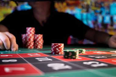 Kumarhanedeki rulet masasında oynayan adam.