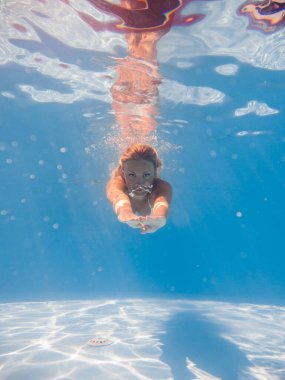 Kadın yüzme havuzunda suyun altında.