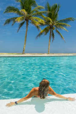 Beş yıldızlı lüks bir kadın, yüzme havuzunda tropik bir tatil köyü.. 