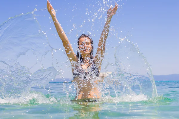 Young woman in the sea splashing water — Stock Photo, Image