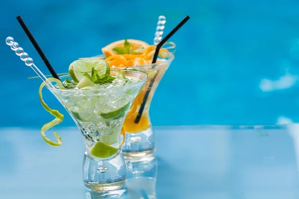 Orange and lime Mojito by the swimming pool — Stock Photo, Image