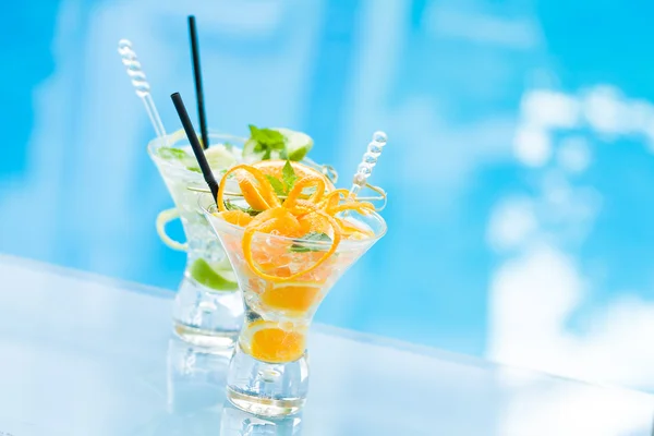 Orange and lime Mojito by the swimming pool — Stock Photo, Image