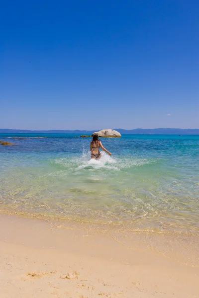 Jeune femme courant dans la mer — Photo