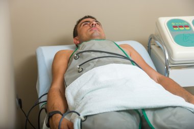 Man receiving an electro therapy  clipart