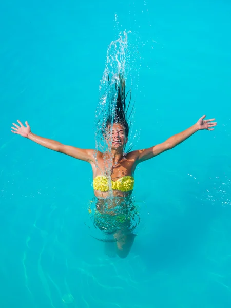 Young tanned girl throwing wet hair back in swimming pool — Stock Photo, Image