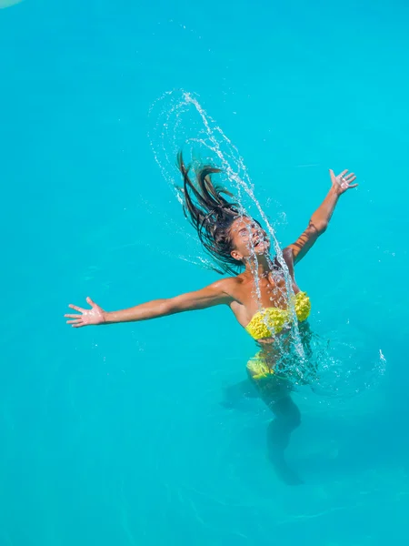 Молода засмагла дівчина кидає мокре волосся назад у басейн — стокове фото