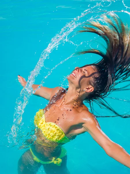 Jovem bronzeada menina jogando o cabelo molhado de volta na piscina — Fotografia de Stock