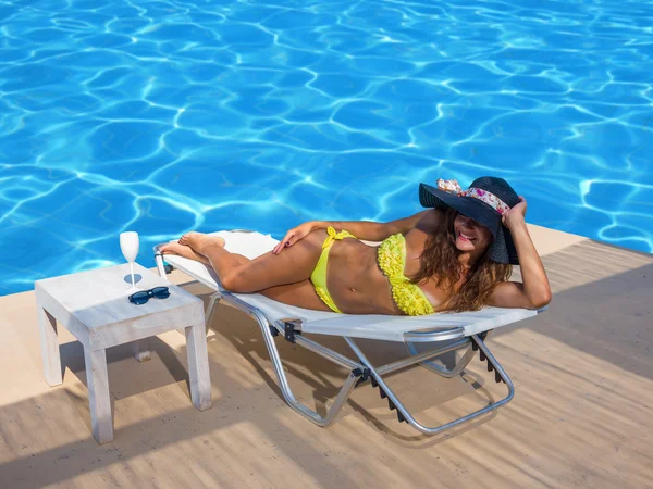 Mujer joven en bikini junto a la piscina — Foto de Stock