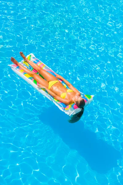 Uma menina está relaxando em uma piscina — Fotografia de Stock