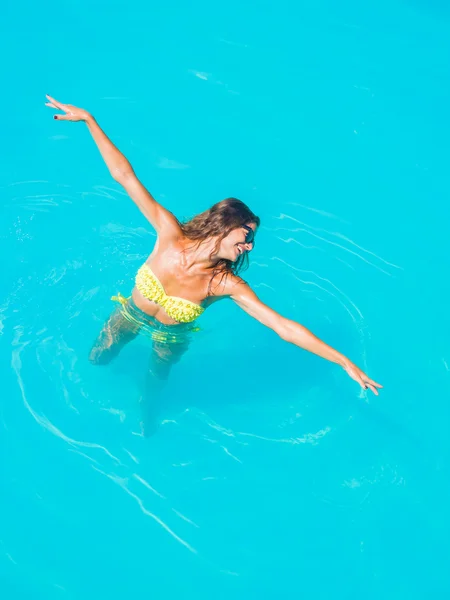 Une fille se relaxe dans une piscine — Photo