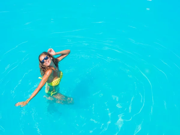 Uma menina está relaxando em uma piscina — Fotografia de Stock