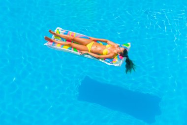 bir kızın rahatlatıcı bir yüzme havuzunda