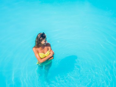 bir kızın rahatlatıcı bir yüzme havuzunda