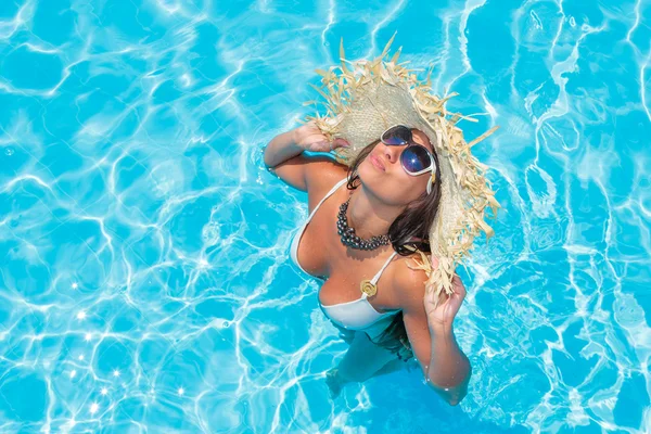 Γυναίκα με ψάθινο καπέλο στην πισίνα — Φωτογραφία Αρχείου