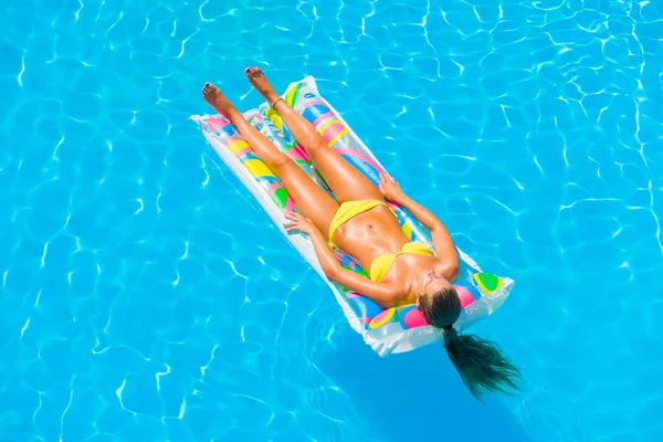 Une fille se relaxe dans une piscine — Photo