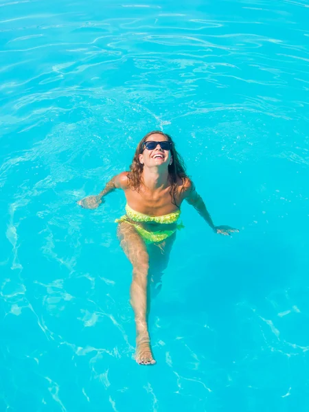 Une fille se relaxe dans une piscine — Photo