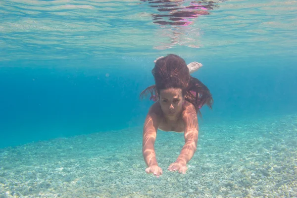 Jeune femme nageant sous l'eau dans la mer — Photo