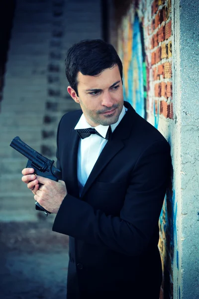 Hitman con esmoquin sosteniendo un arma — Foto de Stock
