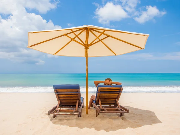 Relaksujące fotele kanapa z parasolem na białej, piaszczystej plaży — Zdjęcie stockowe