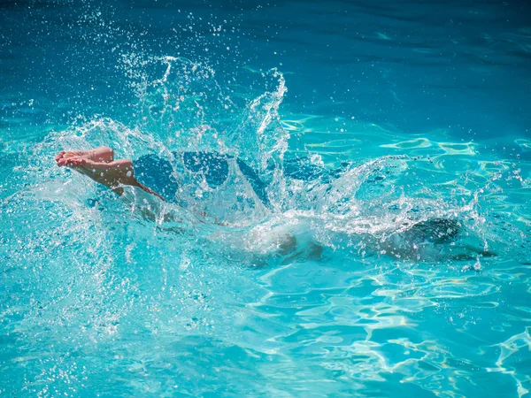 Mujer ensanchándose en una piscina de agua azul — Foto de Stock