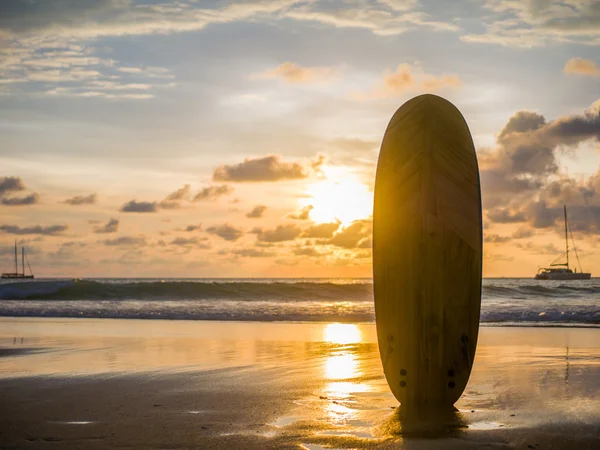 Surf board on the ocean beach at sunset