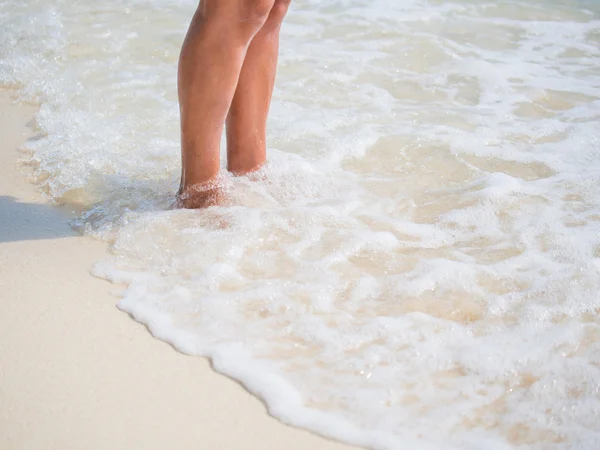 Close-up de pernas de mulher na costa do mar — Fotografia de Stock