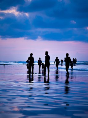 Siluetleri, günbatımında Kuta Bali beach üzerinde ben insanlar