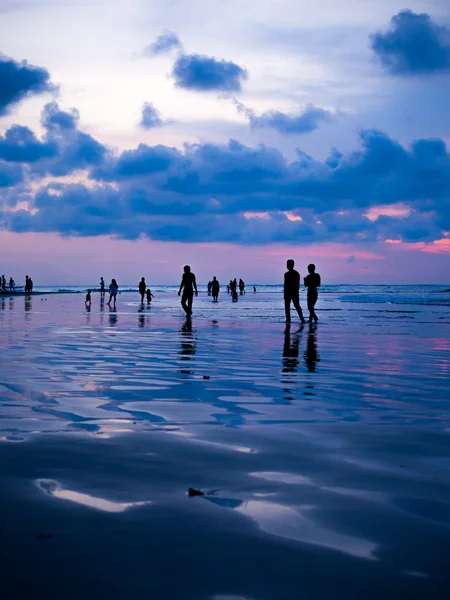 Sylwetki ludzi na zachód słońca na plaży Kuta Bali — Zdjęcie stockowe