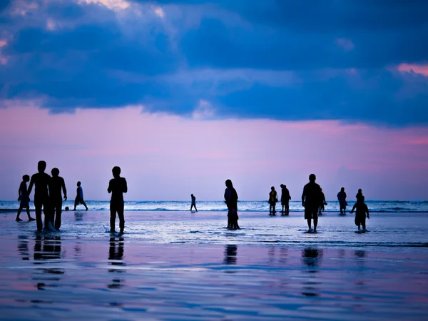 轮廓的人日落时分在巴厘岛库塔海滩 — 图库照片