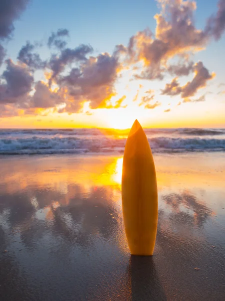 Surfingbräda på stranden vid solnedgången — Stockfoto